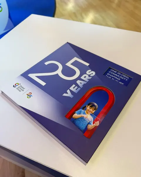 The printed GSG25 book on its plinth at the launch, the cover's red arch framing a child from the key visual.